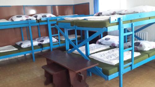 a group of bunk beds in a room with a table at Turistická ubytovna Zámeček in Hojsova Stráž