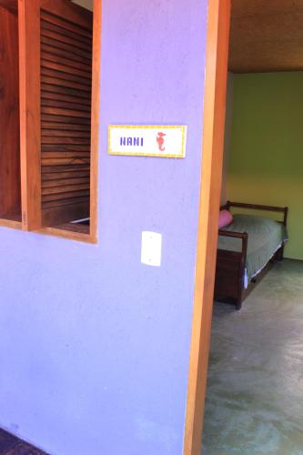 a room with a purple wall with a sign that reads main at Pousada O Canto das Sereias in Trindade
