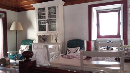 a living room with a bed and a table and chairs at Casa do Progo in Ponte de Lima