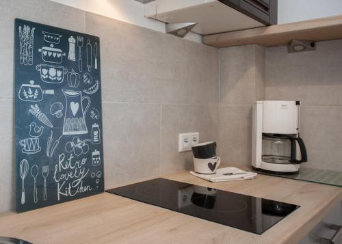 a kitchen with a counter with a coffee maker on a wall at Appartement Maya in Winterberg