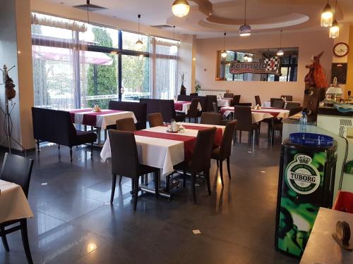 jadalnia ze stołami i krzesłami w restauracji w obiekcie Formula 1 Motel w Bjałej