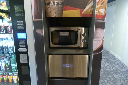 a coffee machine with a microwave in a store at Ibis budget Rouen Petit Quevilly in Le Petit-Quevilly