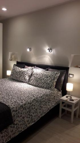 a bedroom with a bed and two lights on the wall at Appartamento Piazzetta La Maddalena in Savona