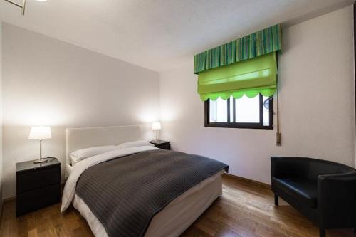 a bedroom with a bed and a window and a chair at Prado Museum Air in Madrid