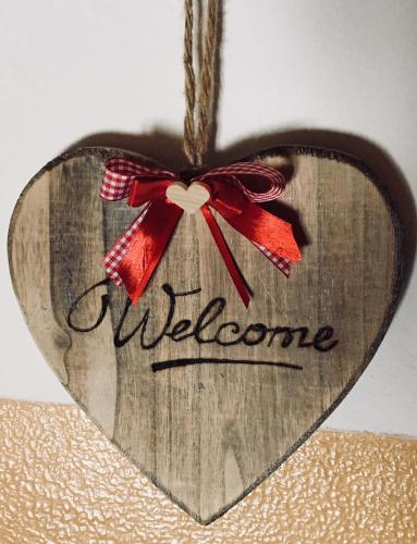 a wooden heart ornament with a red bow at Appartamento Casa Brigadoi in Predazzo