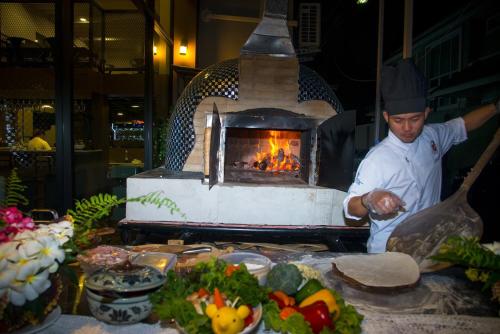 a man standing in front of a fire oven at V20 Boutique Jacuzzi Hotel in Bangkok