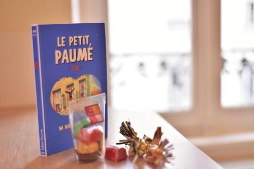 a book sitting on top of a table next to a table gmaxwell gmaxwell at L'Appart Elegance Part Dieu in Lyon