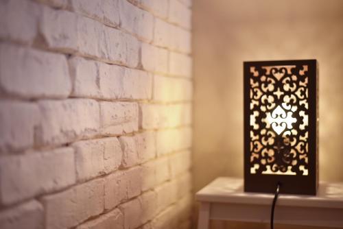 a lamp on a table next to a brick wall at L'Appart Elegance Part Dieu in Lyon