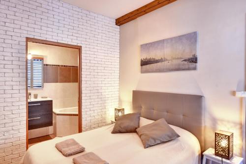 a bedroom with a bed and a bathroom at L'Appart Elegance Part Dieu in Lyon