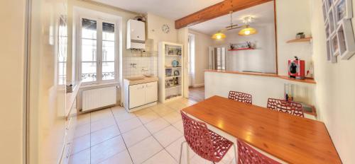 a kitchen with a wooden table and chairs at L'Appart Elegance Part Dieu in Lyon