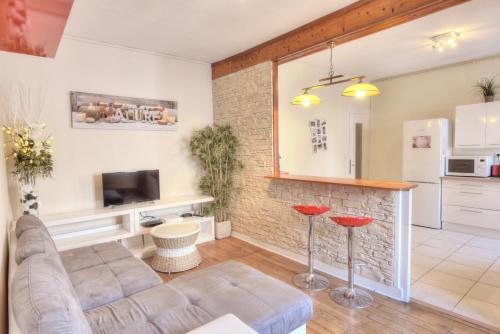 a living room with a couch and a kitchen at L'Appart Elegance Part Dieu in Lyon