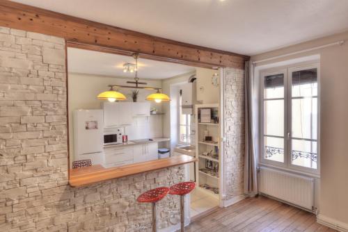 a kitchen with a brick wall and two red stools at L'Appart Elegance Part Dieu in Lyon