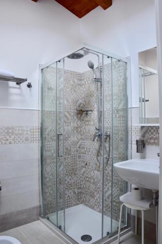 a shower with a glass door next to a sink at Residence Il Portico in Casale Monferrato