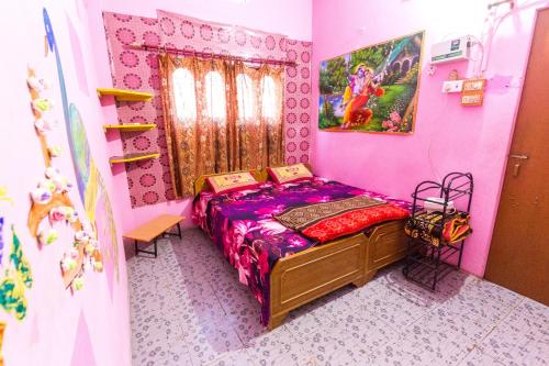 a bedroom with a bed in a pink room at Somit Paying Guest House in Varanasi