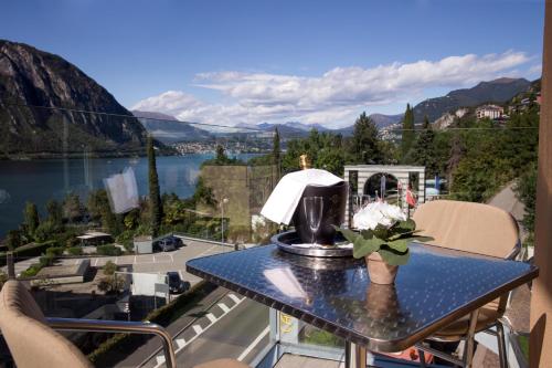 a table with a lamp and a view of a lake at Hotel Campione in Bissone
