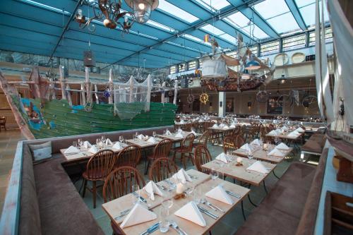 a restaurant with tables and chairs and a large boat at 4-Sterne Superior Erlebnishotel Bell Rock, Europa-Park Erlebnis-Resort in Rust
