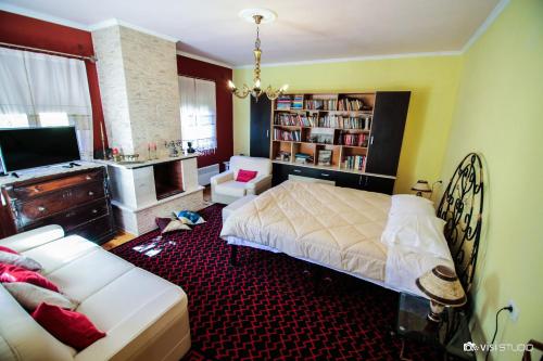 1 dormitorio con cama y sofá en Bujtina Leon's Apartments, en Korçë