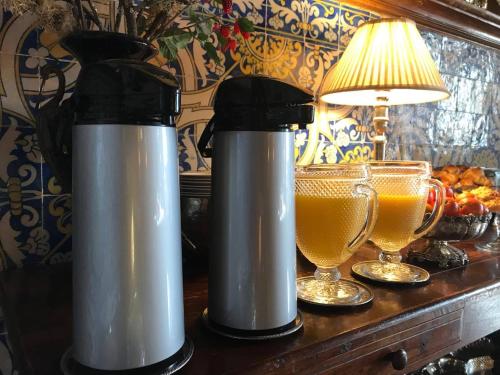 two thermos sitting on a table with two glasses of beer at Hotel Rural Casa dos Viscondes da Varzea in Lamego