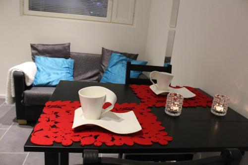 a table with a red table cloth on top of it at Arctic Jokasa Apartment in Rovaniemi