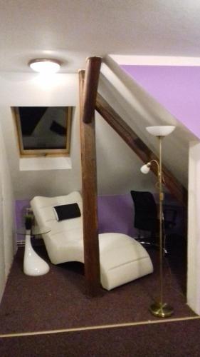 a living room with a white couch and a lamp at Penzion Vulture Havířov in Havířov