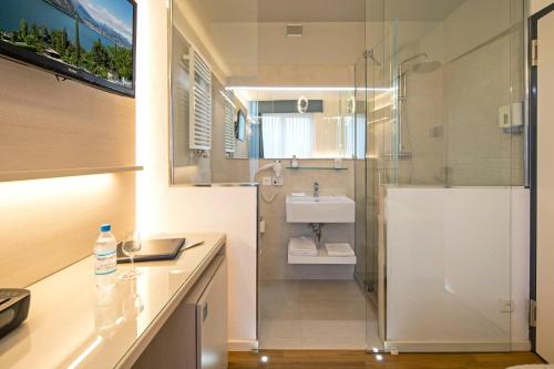 een badkamer met een douche en een wastafel bij Hotel Campione in Bissone
