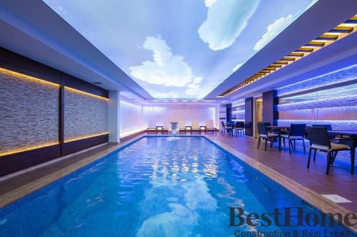 a swimming pool in a hotel with tables and chairs at Best Home 20 Cleopatra Select in Alanya