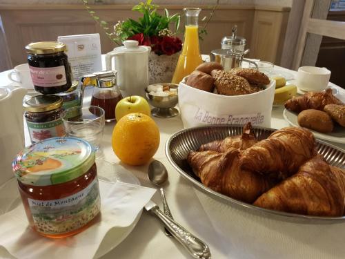 Una mesa cubierta de croissants y otros alimentos para el desayuno. en La Bonne Franquette, en Villé