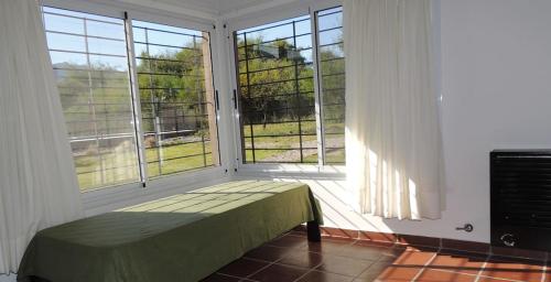 Habitación con ventana grande y banco enfrente. en Verbenas de las Sierras en Cortaderas