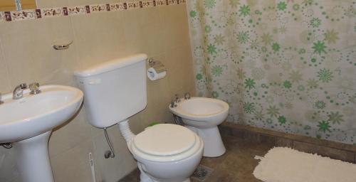 a bathroom with a white toilet and a sink at Verbenas de las Sierras in Cortaderas