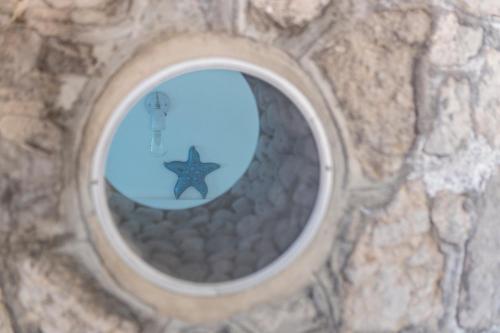 a round window in a stone wall with a star at L'Oblò in Massa Lubrense
