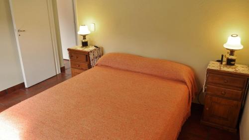1 dormitorio con 1 cama naranja y 2 mesitas de noche en La Simona en Cortaderas