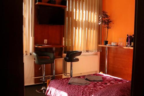 a bedroom with a table and a chair and a desk at Penzion Vulture Havířov in Havířov
