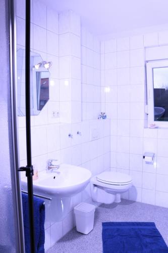 Baño blanco con lavabo y aseo en Strandblick, en Horumersiel