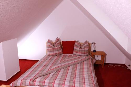ein Bett mit gestreiften Kissen im Dachgeschoss in der Unterkunft Strandblick in Horumersiel