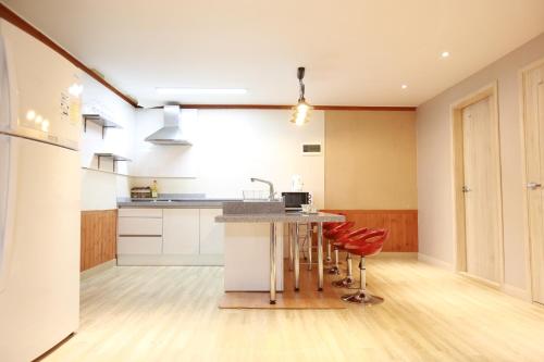 a kitchen with a counter and a island with stools at Daegwanryeong Rodem Tree Pension in Pyeongchang 