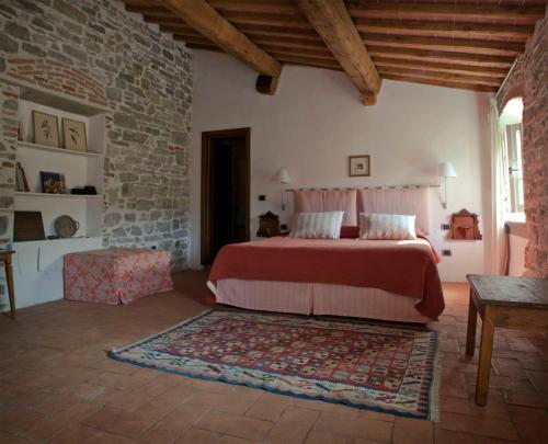 1 dormitorio con cama y pared de ladrillo en Agriturismo Villa Di Campolungo, en Fiesole