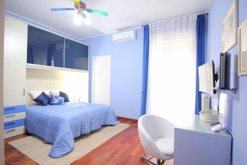 una camera blu con letto e ventilatore a soffitto di Il Giardino delle Jacaranda a Talsano