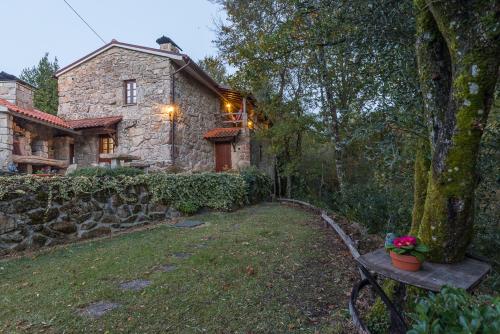 a stone house with a bench in front of it at Varanda do Mouro in Podame