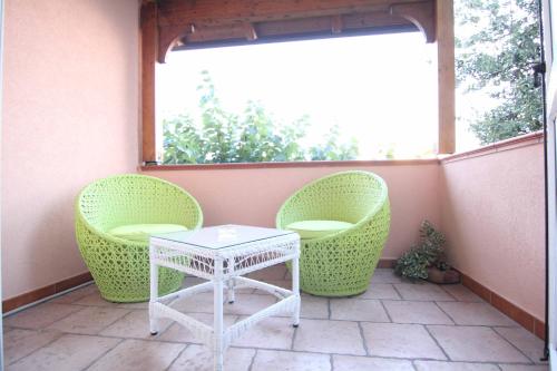 a patio with two chairs and a table and a window at Il Giardino delle Jacaranda in Talsano