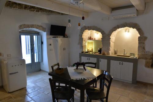 a kitchen and dining room with a table and chairs at Trullo Assenzio in Alberobello