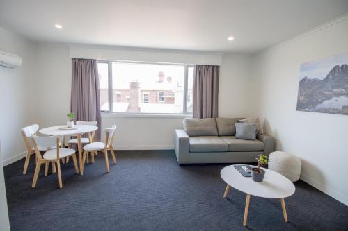 a living room with a couch and a table and chairs at CBD Apartments Launceston in Launceston