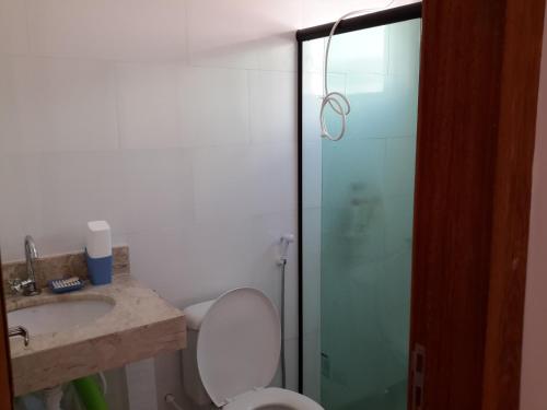 a bathroom with a toilet and a glass shower at Ótima Localização - 4 Quartos in Porto Seguro