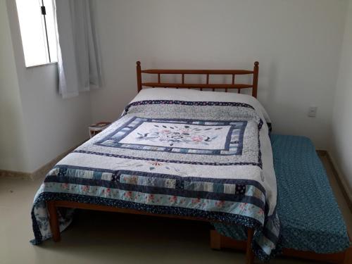 a bed with a quilt on it in a bedroom at Ótima Localização - 4 Quartos in Porto Seguro