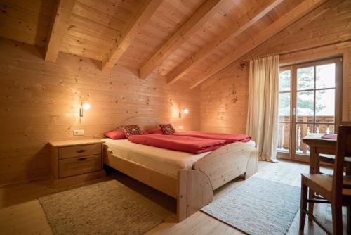 a bedroom with a bed in a wooden cabin at Oberschupferhof in Außervillgraten
