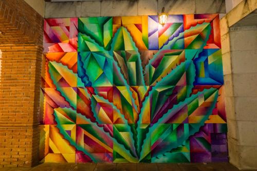 a colorful mural on a brick wall at NaNa Vida Hotel Oaxaca in Oaxaca City