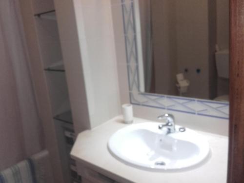 a bathroom with a white sink and a mirror at Albufeira INN - Casa Litty - Bellavista T1 duplex in Albufeira