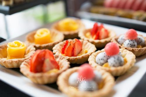 a tray of mini pies with strawberries and fruit at Orchid Classic Cruise in Ha Long
