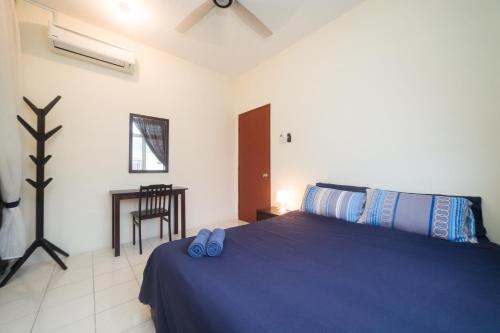 a bedroom with a bed with blue slippers on it at Szhnn's Vacation Apartment in Kota Kinabalu