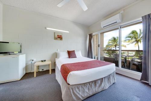 ein Hotelzimmer mit einem Bett und einem großen Fenster in der Unterkunft Camelot Motel in Gladstone