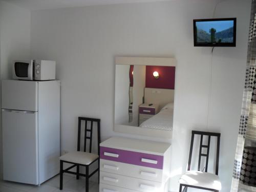 a small room with a bed and a refrigerator at Hotel Lo Monte in Pilar de la Horadada